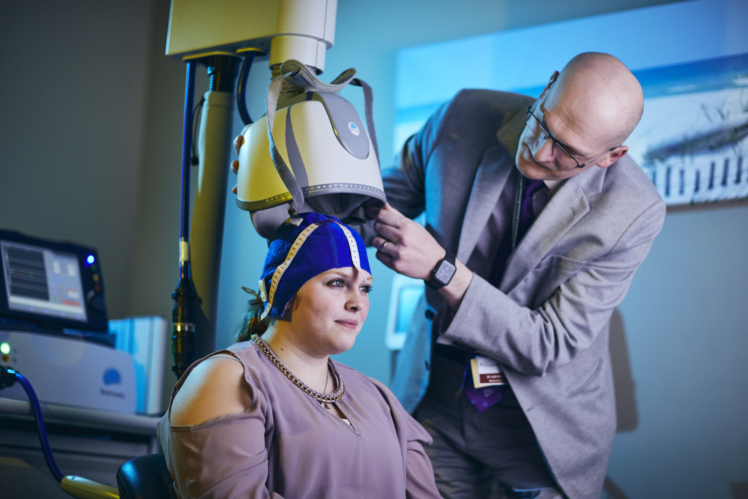 doctor using TMS therapy device on patient