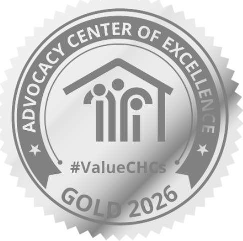 A silver badge with “ADVOCACY CENTER OF EXCELLENCE,” a house with three figures, “#ValueCHCs,” and “GOLD 2026” written on it.